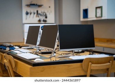 Empty software developer office workplace with a desk with multiple computer screen. - Powered by Shutterstock