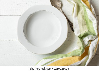 Empty Soup Plate With Spoon On White Background From Above With Copy Space