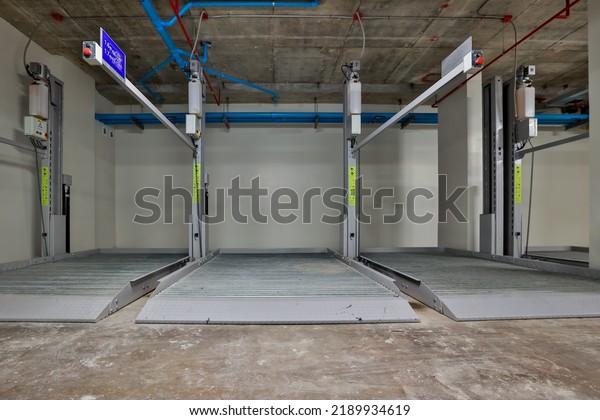 Empty Space in Automatic Elevator double stack\
car park. Hydraulic lift. Empty garage. Hydraulic machine for\
lifting car indoor\
parking.