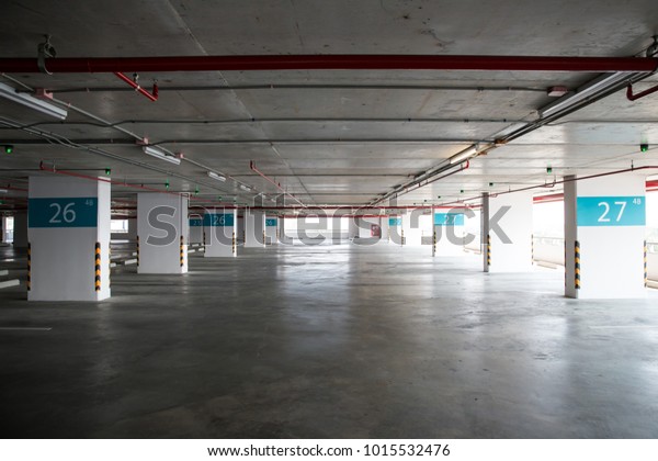 Empty space car park interior at afternoon. Indoor\
parking lot. interior of parking garage with car and vacant parking\
lot in parking building. some carpark empty in Condominium or\
department store.