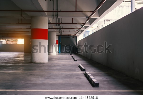Empty space car park interior at morning.Indoor\
parking lot.interior of parking garage with car and vacant parking\
lot in parking building.some carpark empty in Apartment or\
department store.
