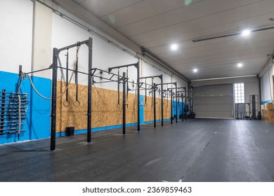 Empty space of a cross training room with bars and Olympic rings