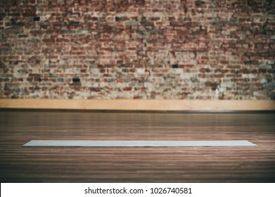 Empty Space In Fitness Center, Brick Wall, Natural Wooden Floor, Modern Loft Studio, Unrolled Yoga Mat On The Floor. No People.