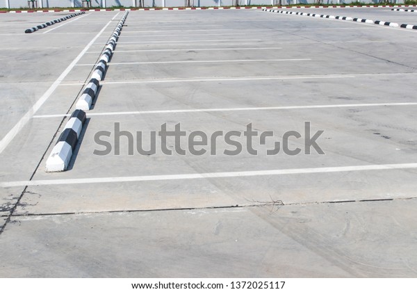 Empty space in the parking lot or\
the outdoor car park with black and white concrete\
barrier