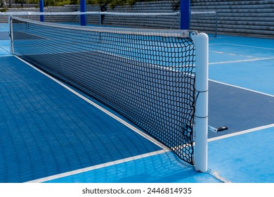 Empty space of a pickleball net in a blue outdoor court wit no people - Powered by Shutterstock