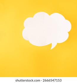 Empty speech bubble in a shape of cloud made of white paper on a yellow backround.Copy space