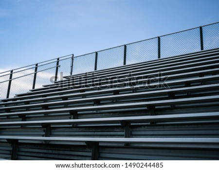 Empty Sports Stadium Metal Bleachers 
Blue Sky