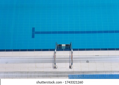 Empty Sports Swimming Pool. Swimming Pool Edge With A Steel Ladder. Top View Horizontal Orientation