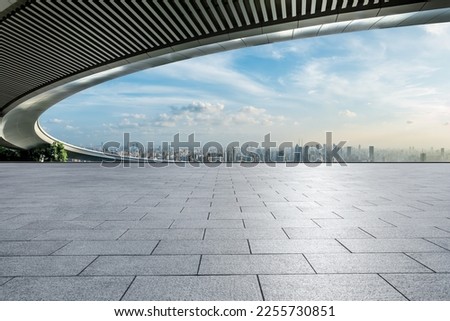 Empty square floor and bridge with city skyline at sunset in Shanghai, China.