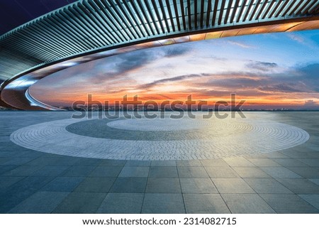 Empty square floor and bridge with city skyline at sunset