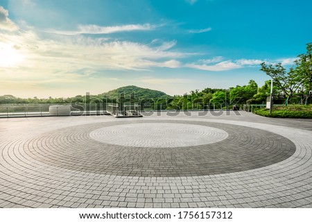 Empty square floor and green mountain landscape at sunset.