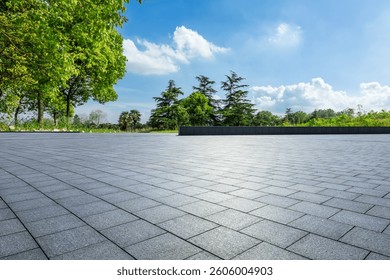 Empty square floor and green trees under a sunny blue sky