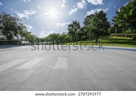 Empty square floor with green trees and blue sky sun background in the park.