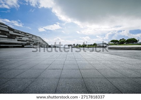Empty square floor and modern architecture with blue sky background.