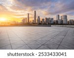 Empty square floor with modern city buildings scenery at sunset in Guangzhou. car advertising background.