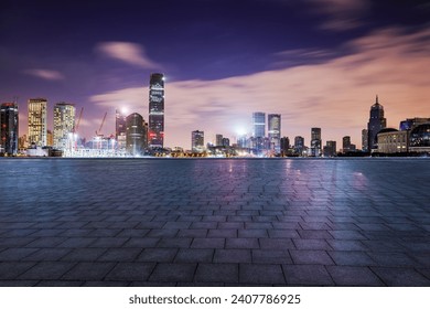 Empty square floor and modern city buildings at night in Shanghai - Powered by Shutterstock