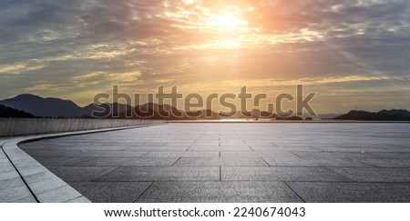 Empty square floor and mountain with sea at sunset