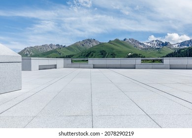 Empty square floor and mountains under blue sky