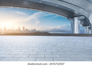 Empty square floors and bridge with modern city skyline scenery at sunrise 