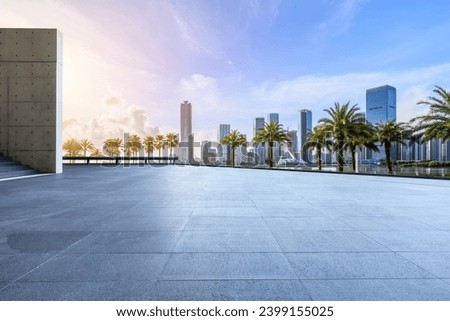 Empty square floors and city skyline with modern buildings at sunset