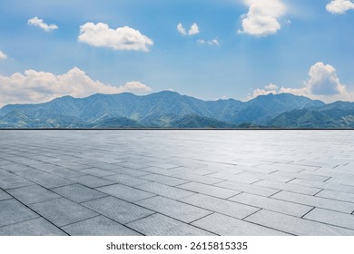 Empty square platform and green mountain scenery under clear sky 