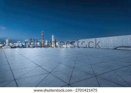 Empty square platform with a panoramic view of the modern city financial district skyline at night.