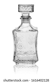 Empty square-shaped glass decanter, closed with a glass stopper. On a white background with reflection