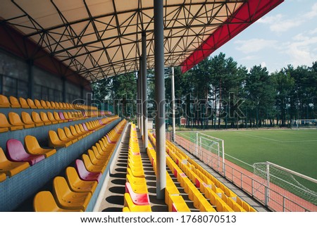 Empty stadium. Rows of yellow and red seats in stadium. Concept of empty stadium without spectators, quarantine time
