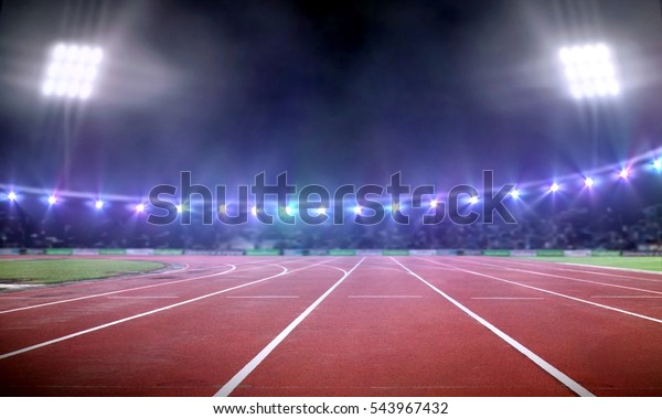 Empty\
stadium with running track under spotlight at\
night