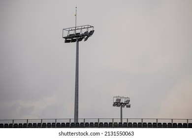 Empty Stadium Seats From Behind. Stadium Reflector Lights In Background.