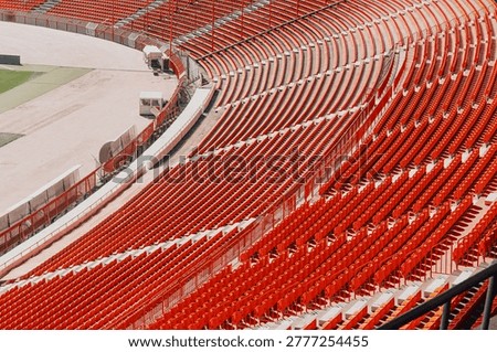 Empty stadium seats creating a patterned background. Bright orange bleachers in an athletic arena awaiting spectators