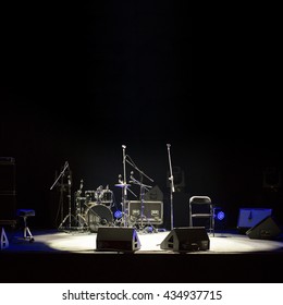 Empty stage at concert, drum kit, microphones and audio speakers