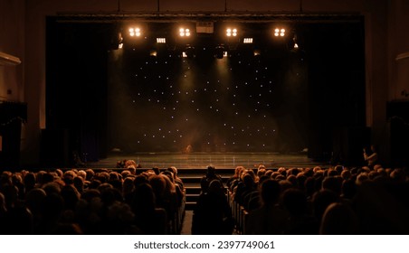An empty stage of the theater, lit by spotlights and smoke before the performance