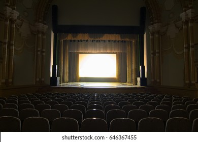 An empty stage of the theater, lit by spotlights and smoke before the performance