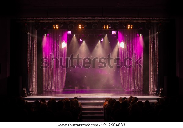 An empty stage of the theater, lit by\
spotlights and smoke before the\
performance