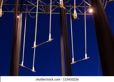 Empty standing trapezes against dark blue sky at twilight
