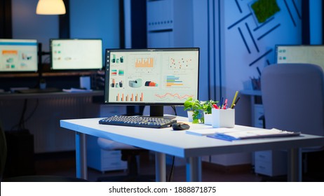 Empty Start Up Business Office With Modern Design During Night With Graphics Running On The Desktop. Financial Company With Nobody In It, Place Of Work Startup, Workplace Indoors Concept