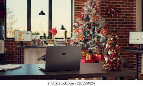 Empty startup office decorated with christmas lights and tree to celebrate winter holiday season. Festive decorations and ornaments in workplace, seasonal xmas decor for gifts and presents. - Shutterstock ID 2203559269