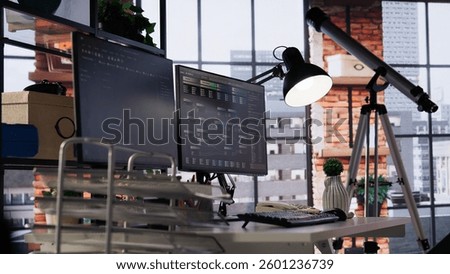 Empty startup office with program running on PC debugging applications in different software languages. Code testing and quality assurance done on computers in workplace, dolly in shot
