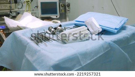 In an empty sterile operating room there are surgical instruments and a table covered with a surgical field. The surgery is ready for the operation. The concept of undercutting the operating room.