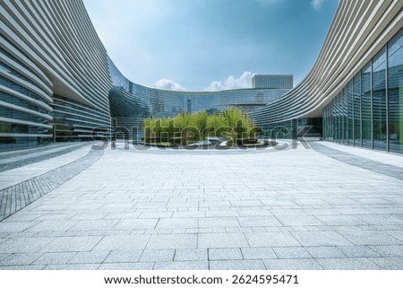 Empty stone paved square in front of modern curved office buildings. Business architecture and urban space background.