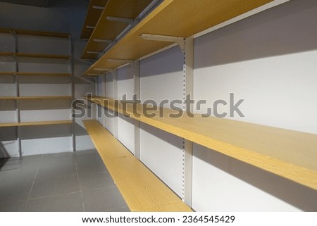 Empty store shelves viewed from the side.