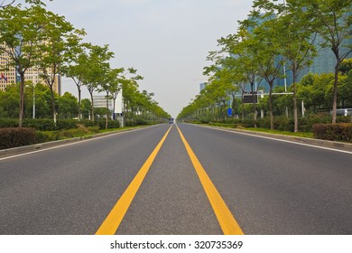 Empty Straight Line Road Surface With Modern City Buildings Background