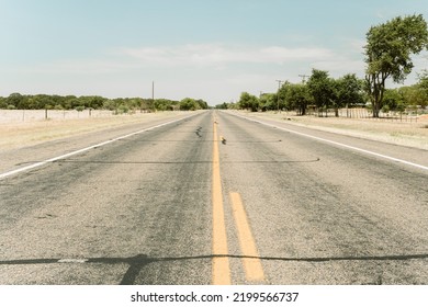 Empty Straight Road Leading To The Horizon In Rural Texas Area In Warm Filmic Colors