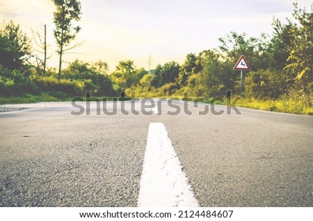 Empty Straight Road in the Middle of the Forest in Croatian Countryside. Asphalt Groung with White Lines to the Center. Trees and Natural Landscape Aside the Road.