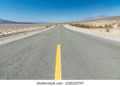 Empty Straight Road Thru The Death Valley With Yellow Median, USA