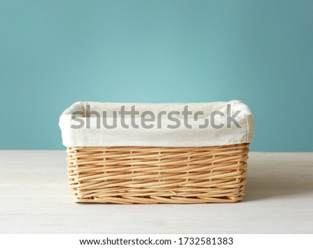 Empty straw basket with white linen on wooden table.Food container empty space.