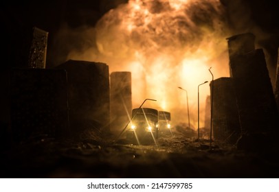 Empty street of burnt up city, flames on the ground and blasts with smoke in the distance. Apocalyptic view of city downtown as disaster film poster concept. Night scene. City destroyed by war. - Shutterstock ID 2147599785