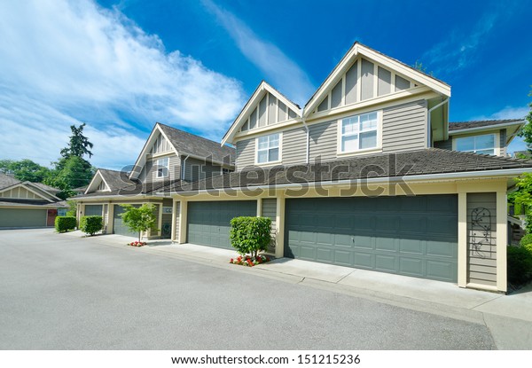 Empty street\
of the nice neighborhood with the houses with double doors garages\
in the suburbs of Vancouver,\
Canada.