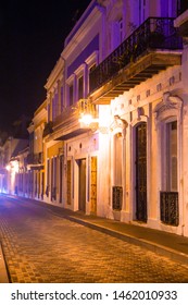 Empty Street Scene From Old San Juan Puerto Rico At Night With Buildings And Cobblestones. 